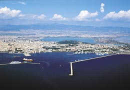 Un'immagine aerea della parte orientale della citt di Cagliari e del suo entroterra. In primo piano, l'imboccatura del porto storico. Sulla sinistra un cargo Tirrenia ed un traghetto della Moby Lines